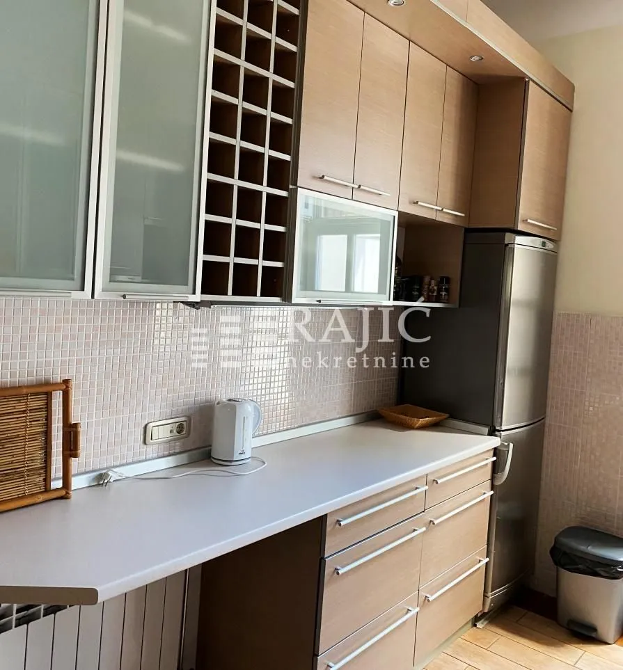 View of the kitchen with wooden cabinetry and countertop.