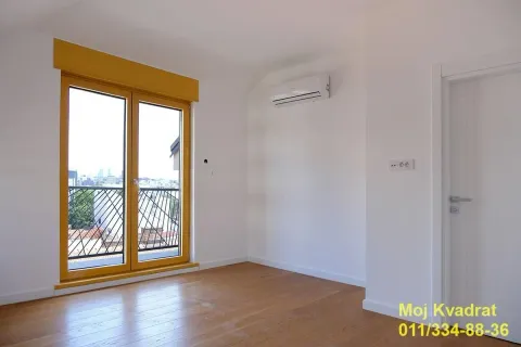 Prazna soba sa drvenim podom, klima uređajem i balkonskim vratima. - image 6