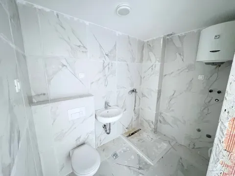 Novoopremljeno kupatilo sa mermernim pločicama, umivaonikom i wc šoljom. - image 6