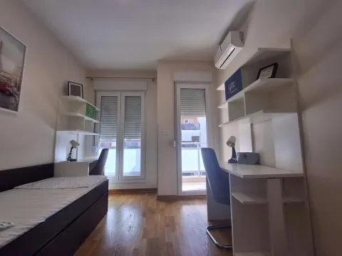 Children's bedroom with a bed, desk, and shelving. - image 10