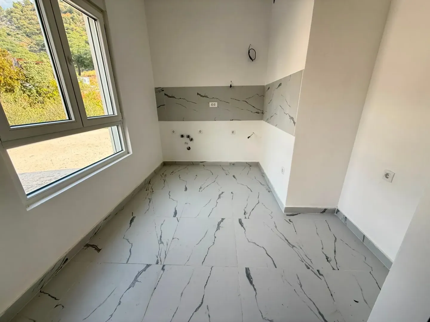 Nove pločice i pripremljene instalacije u novoj kuhinji.