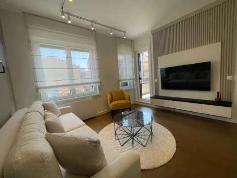 Modern living room with a sofa, TV, and coffee table. - image 6