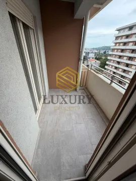 Manji popločani balkonski prostor sa pogledom na okolne zgrade. - image 11