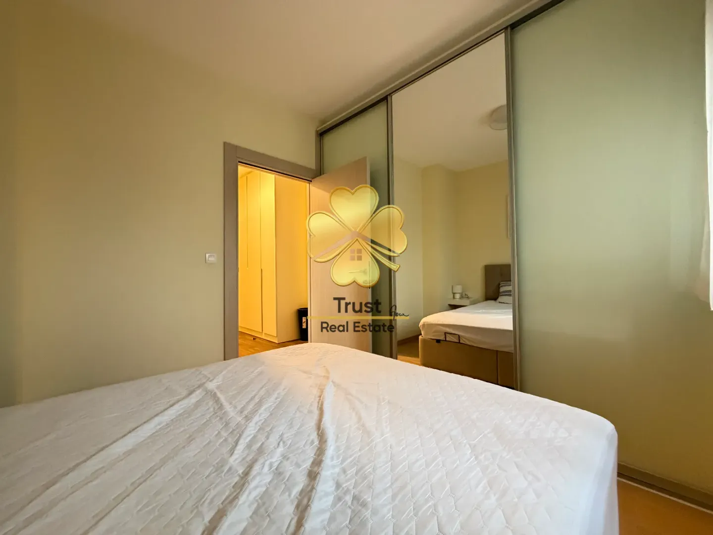 Spavaća soba sa bračnim krevetom i ugradnim plakarom sa ogledalom.