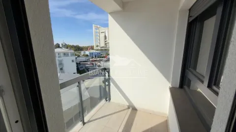 Manji natkriveni balkon sa staklenom ogradom i pogledom na ulicu. - image 7