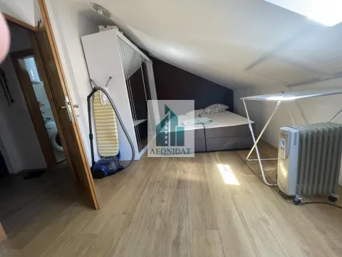Attic bedroom with a double bed, wardrobe, and sloped ceiling. - image 8