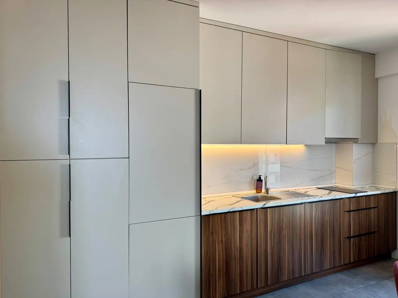Modern kitchen with wooden elements and marble countertops.