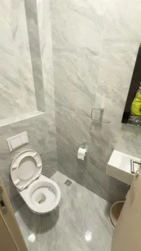 Manje kupatilo obloženo sivim mermernim pločicama sa wc šoljom i umivaonikom. - image 6
