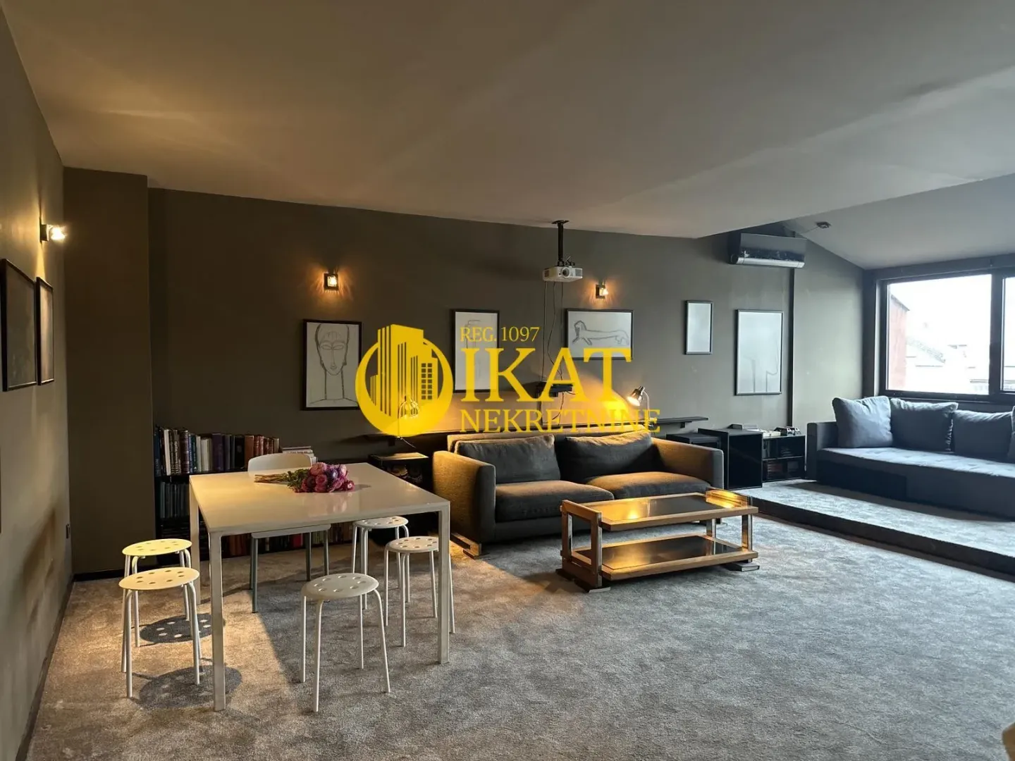 Spacious living room with a dining area, seating set, and bookshelves.