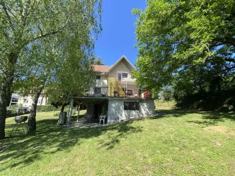 Pogled na dvorište i spoljašnjost kuće okružene zelenilom. - image 3