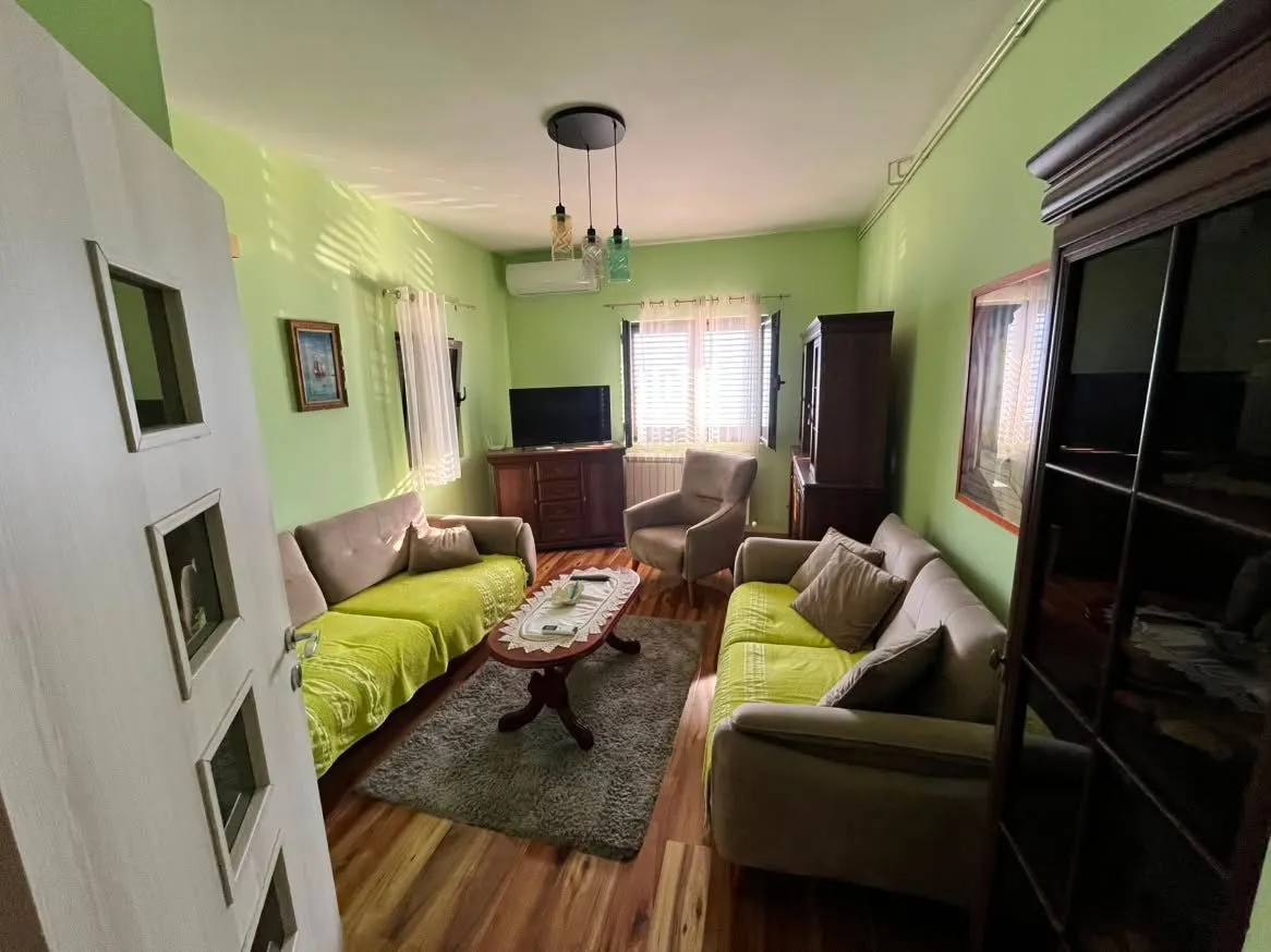 Living room with sofas, an armchair, a coffee table, and a TV.