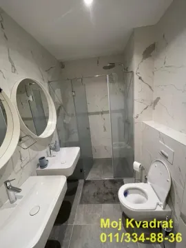 Modern bathroom with two washbasins, a walk-in shower, and a toilet. - image 15
