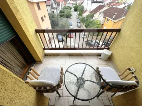 Manji namješteni balkon sa stolom i dvije stolice i pogledom na ulicu. - image 10