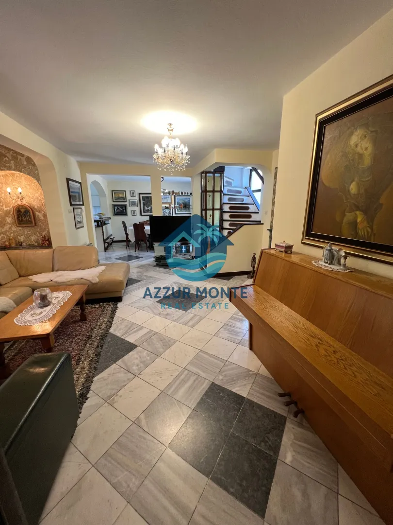 Spacious living room with a piano and marble floor.