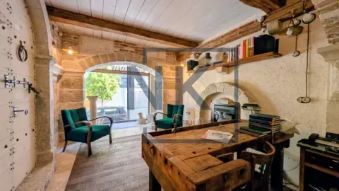 Rustic living room with stone walls, wooden beams, and unique furniture. - image 2