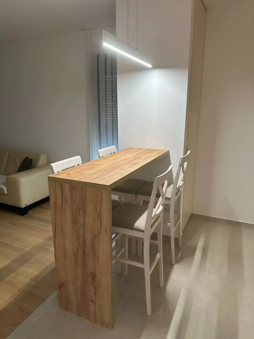 Trpezarijski sto sa visokim stolicama u modernom enterijeru.