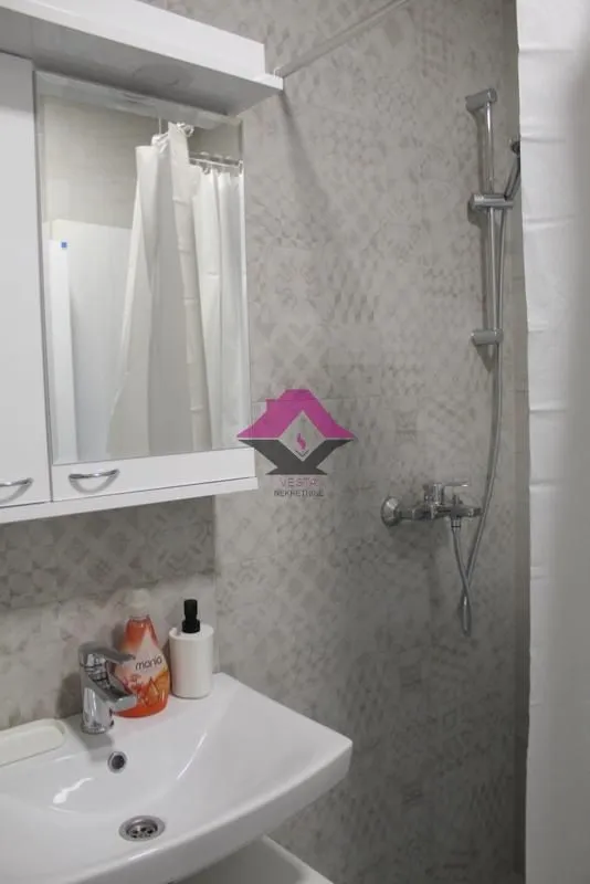 Small bathroom with a sink, mirror, and shower.