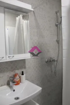 Small bathroom with a sink, mirror, and shower. - image 10