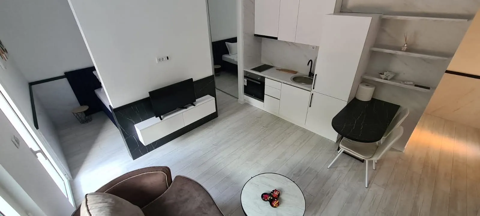 High-angle view of a bright living room with a kitchen and dining area.