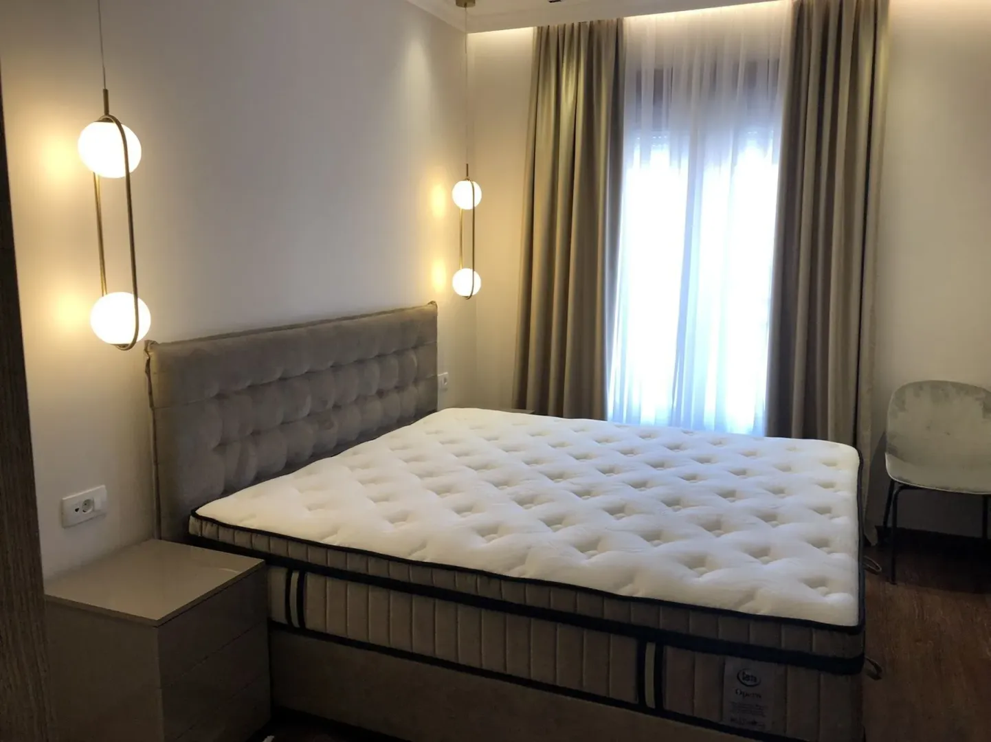 Bright bedroom with a large double bed and modern lighting.