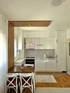Modern white kitchen with wooden details and a dining table. - image 4