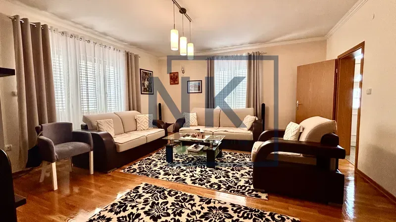 Spacious living room with seating furniture, coffee table and rugs.