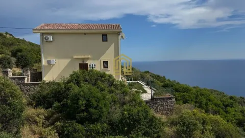 Spoljašnji izgled kuće sa pogledom na more i zelenilom u okruženju. - image 17