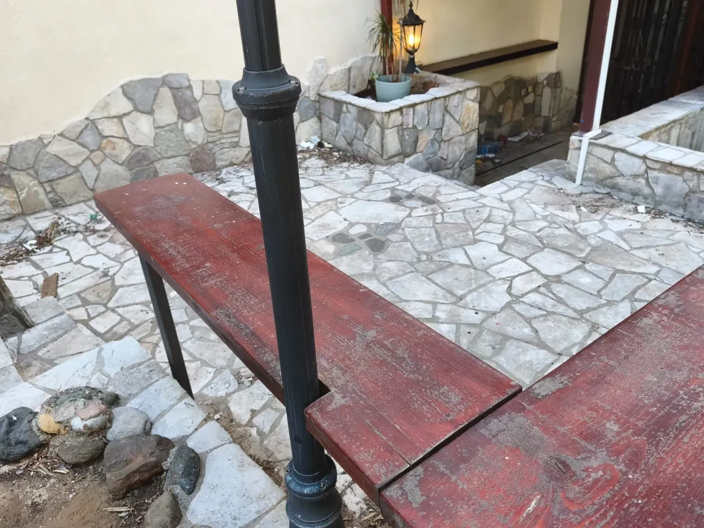 Paved courtyard with a wooden bench and a street lamp post.