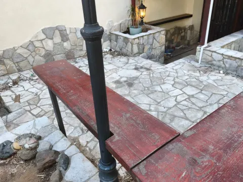 Paved courtyard with a wooden bench and a street lamp post. - image 2