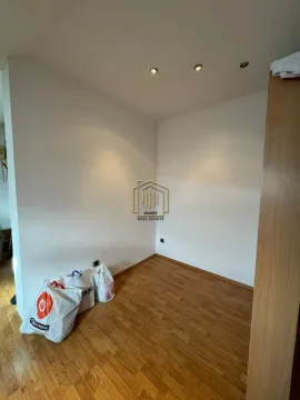 Prazna soba sa laminatom i bijelim zidovima na kojima su kese sa stvarima. - image 17