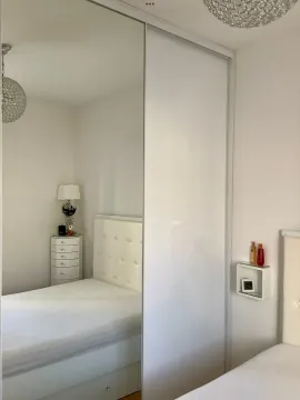 Svjetla spavaća soba sa velikim ugradnim ormarom i krevetom. - image 6