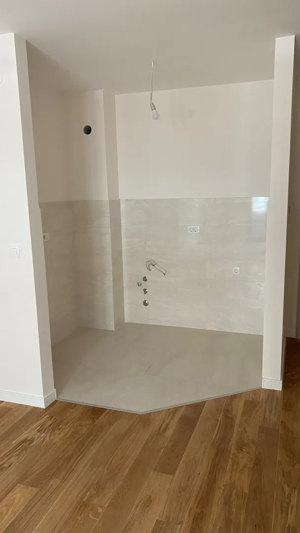 Unfurnished kitchen niche with installed wall tiles.