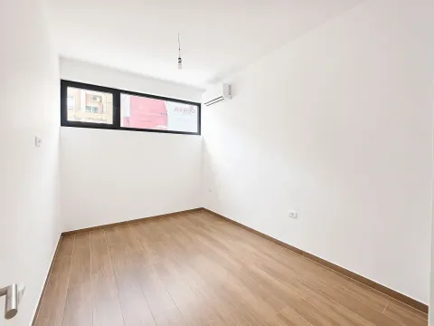 Prazna svijetla prostorija sa bijelim zidovima, drvenim podom i klima uređajem. - image 6