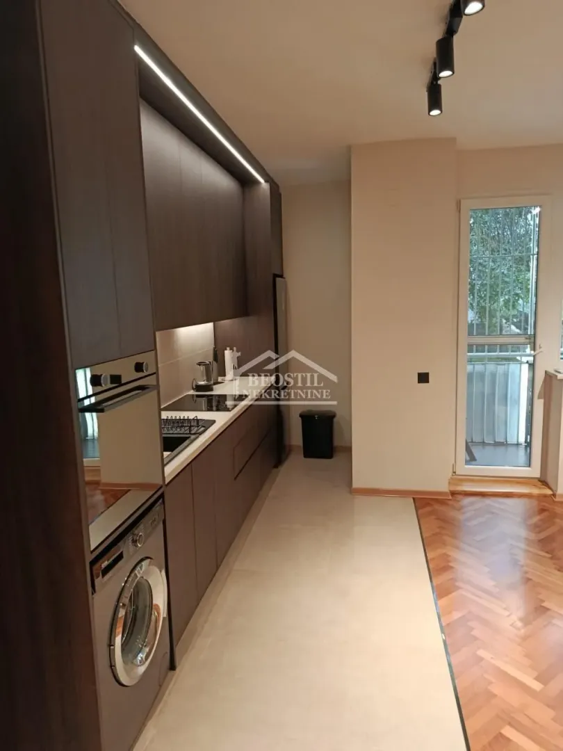 Modern kitchen with built-in appliances and a washing machine.