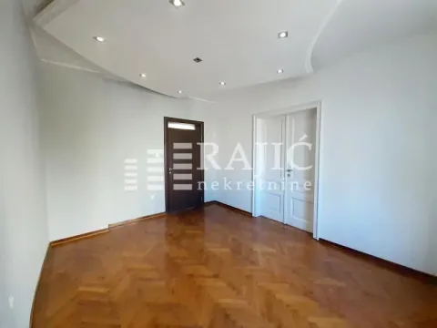 Empty room with parquet flooring and suspended ceiling with lighting. - image 4