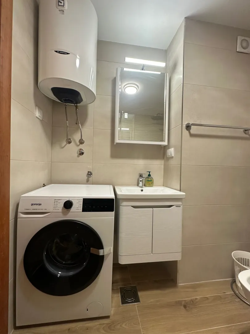 Bathroom equipped with a washbasin, washing machine, and water heater.