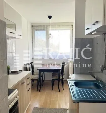 Kitchen with a dining area and light wood cabinetry. - image 7