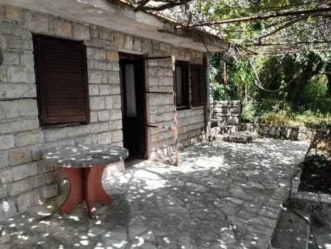 Kamena kuća sa popločanim dvorištem i stolom u hladu. - image 7
