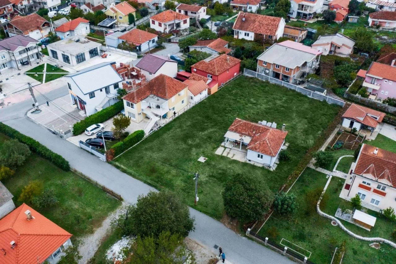 Pogled iz vazduha na kuću sa prostranim dvorištem u naselju.