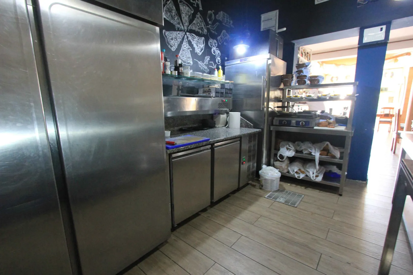 Commercial kitchen with stainless steel elements and refrigeration units.