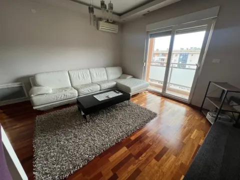 Living room with a white sectional sofa, rug, and access to the terrace. - image 4