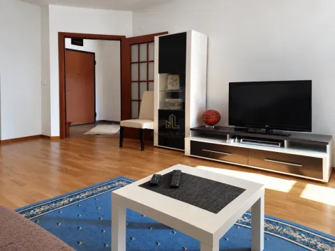 Living room with a sofa, TV, and coffee table. - image 2
