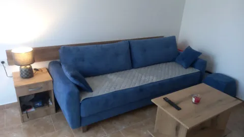 Living room with a blue sofa and a wooden coffee table. - image 2