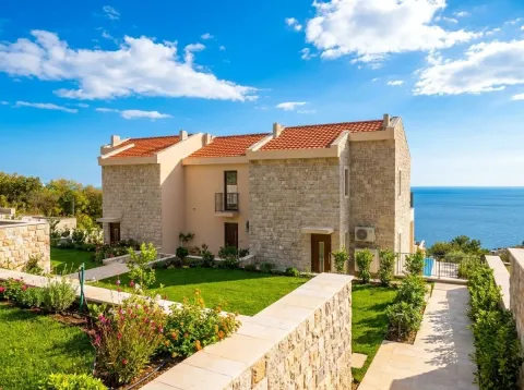 Exterior view of the stone house with a landscaped yard and sea view. - image 3