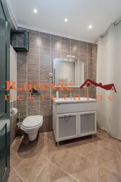 Bathroom with a vanity sink, toilet, and a shower area with a curtain. - image 11