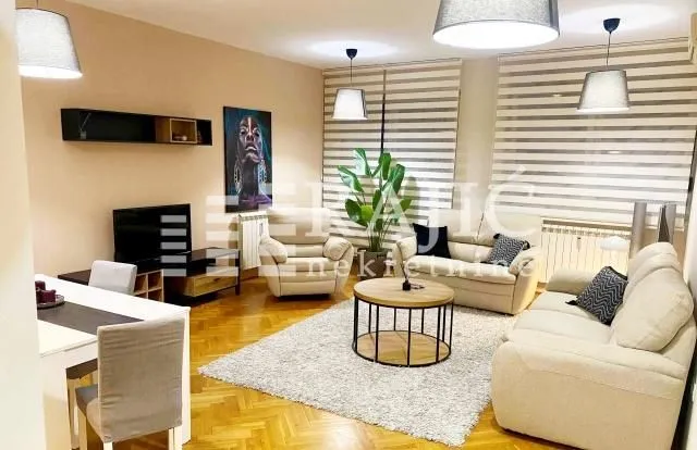Spacious living room with a sofa set, dining table, and modern lighting.