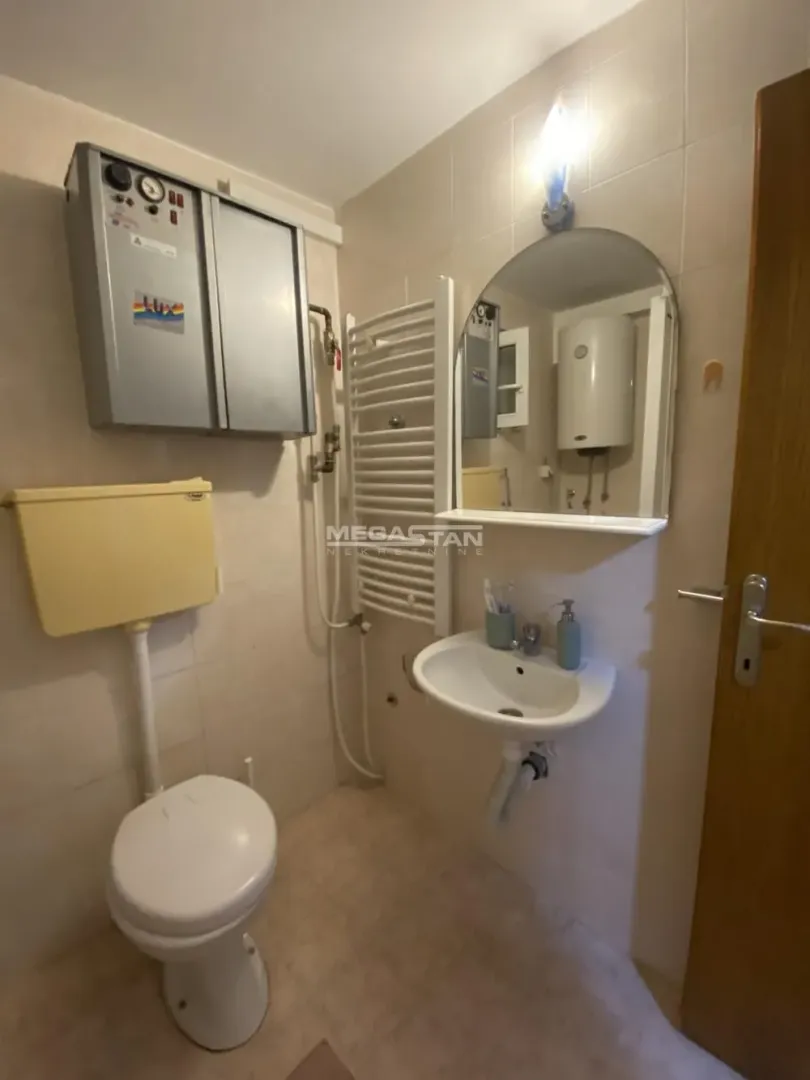 Small bathroom with a toilet, washbasin, mirror and a towel radiator.