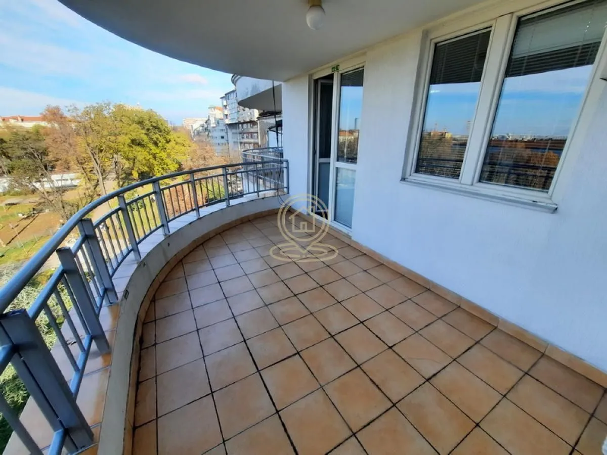 Spacious semicircular balcony with tiled flooring and a metal railing.