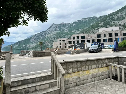 View of the surrounding buildings, road, and mountain landscape near the water. - image 11