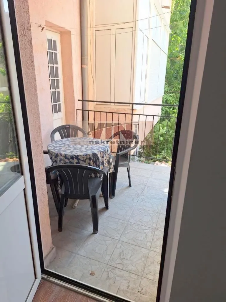 Namešten balkon sa stolom i stolicama.